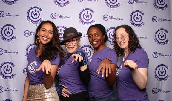 Four women posing in front of Tech Intersections backdrop